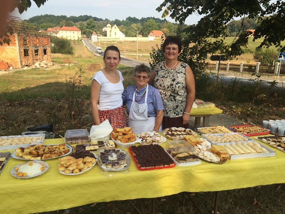Štefica Tominović (lijevo) sa članicama udruge u svom selu, kraj stola punog domaćih kolača